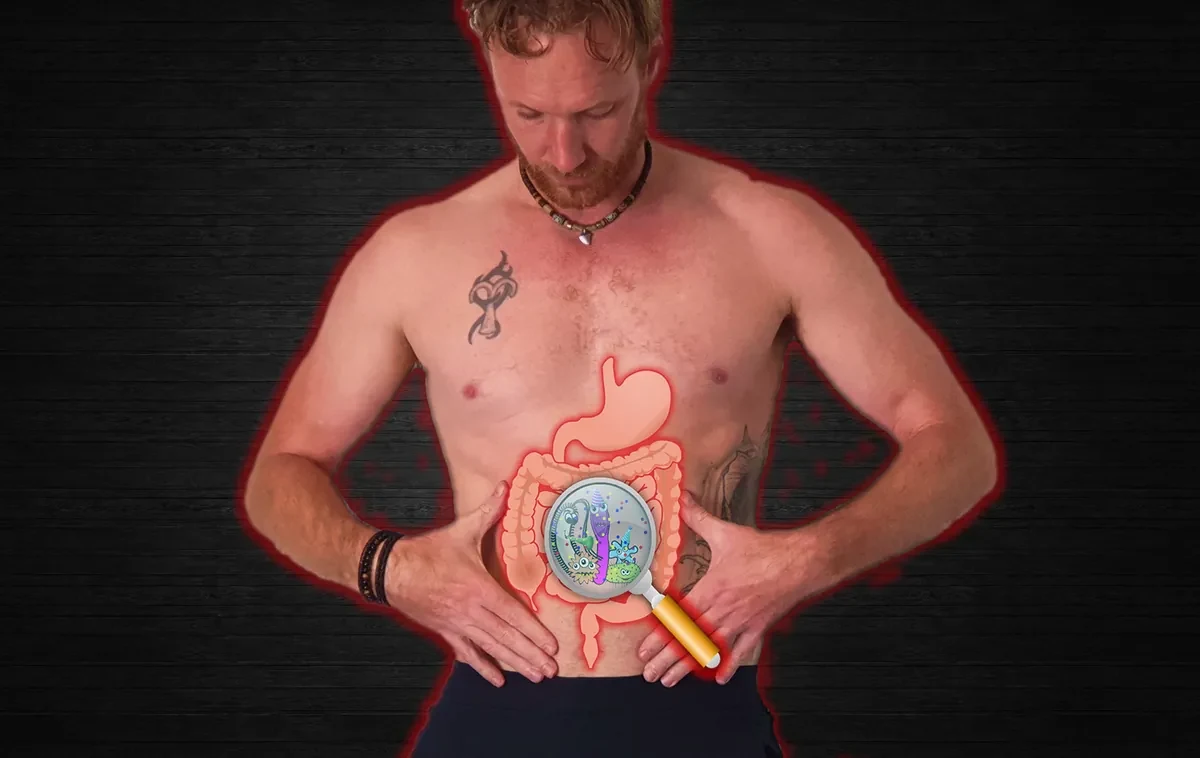 A man holding his midsection with an illustrated digestive tract overlaid and a magnifying glass revealing gut bacteria