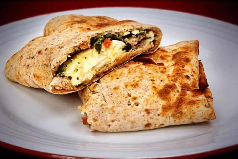 A sprouted grain wrap filled with egg whites, spinach and tomato