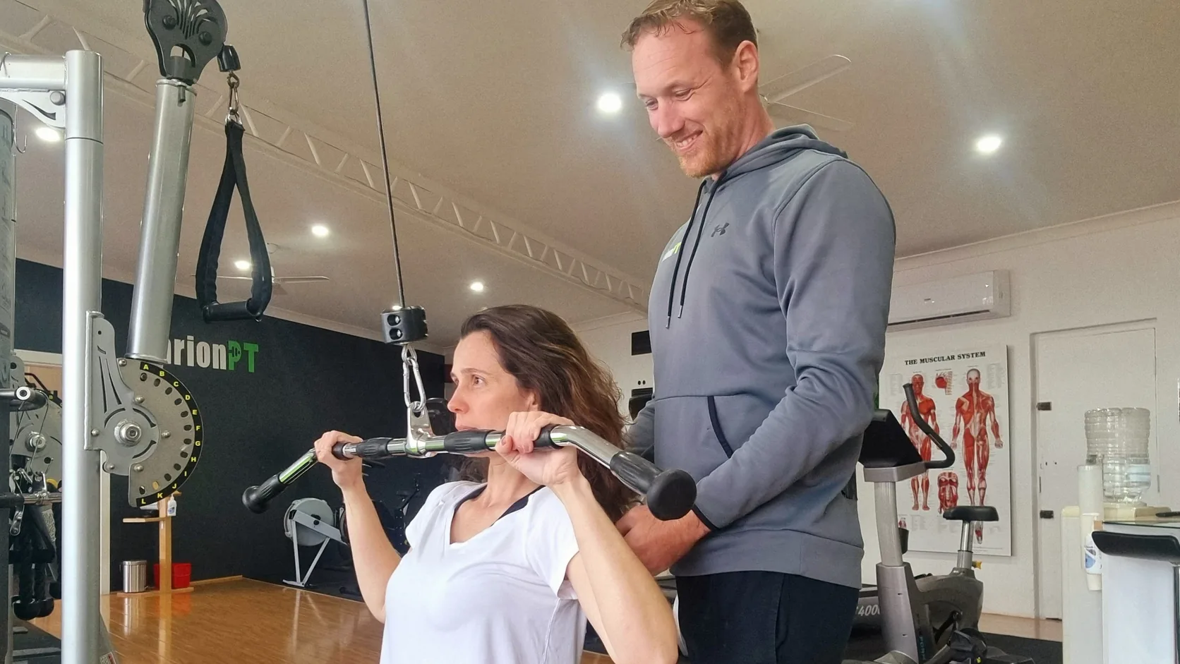 A MarionPT coach supporting a member through a lat pulldown in the Warradale studio